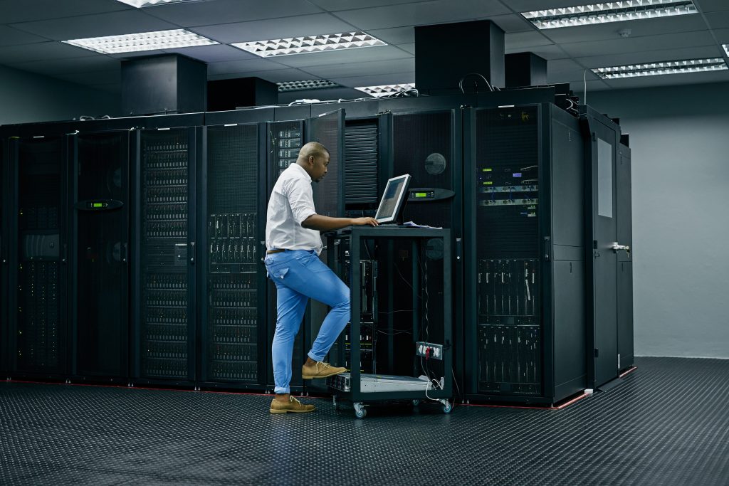 Skilled in all things IT. Shot of an IT technician using a computer while working in a data center